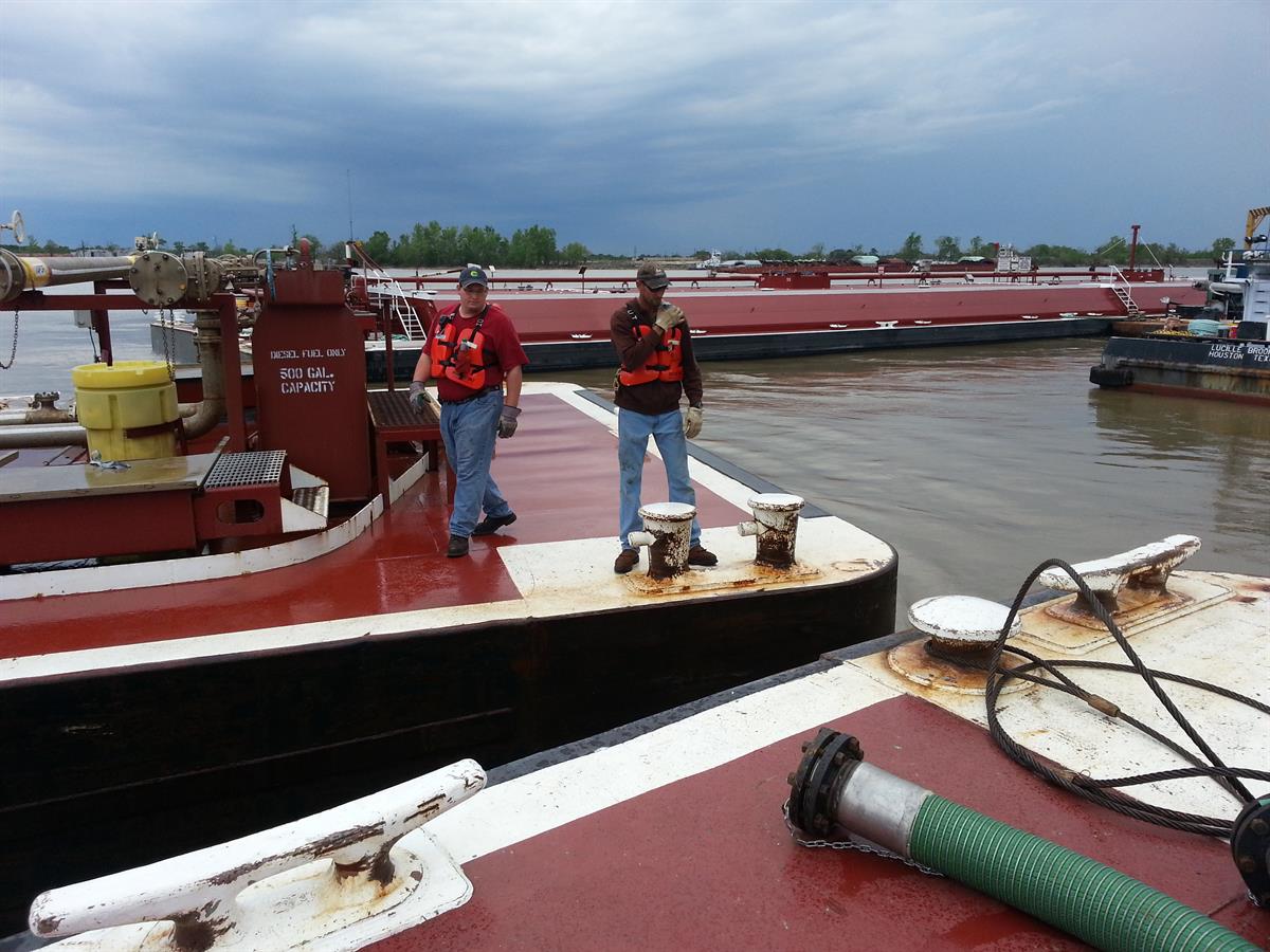 Deckhands pulling a barge into dock